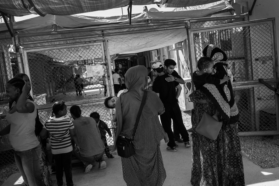 Mothers with children in front of the safe area for children at the refugee camp Moria, Lesbos, Greece